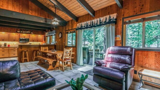 A wooden interior with a kitchen, dining area, and seating.