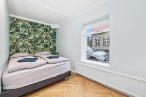 Een slaapkamer met een bed, een raam en uitzicht op de omgeving.
