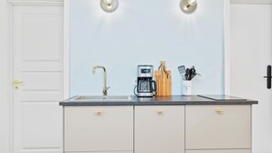 Eine Küche mit doppelter Spüle, einer Kaffeemaschine und einem Messerblock auf der Arbeitsfläche.
