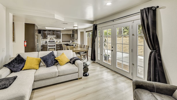 A spacious living room with a sofa, a dining area, and a kitchen in the background. - 2 Mi to Victoria Gardens: Rancho Cucamonga Haven (Rancho Cucamonga)