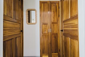 Un pasillo con puertas de madera y un espejo en la pared.