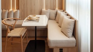 Ein modernes Interieur mit einer Wandpaneele aus Holz, einem Esstisch, einer gepolsterten Bank und einer schwarzen Matte.