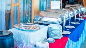 A buffet setup with multiple serving stations and stacked plates. - Bethany Hotel Karongi (Bwishyura)