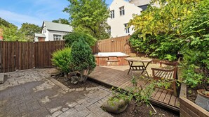 A backyard with a wooden deck, hot tub, and patio furniture. - Central studio apartment (Reykjavik)