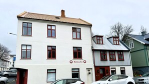 A building with a sign reading "Baldursbräu" and two parked cars in front. - Central studio apartment (Reykjavik)