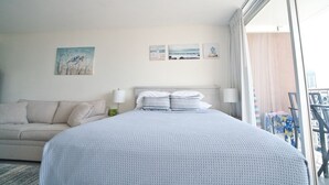 Une chambre d’hôtel avec un grand lit, un canapé et un balcon offrant une vue.