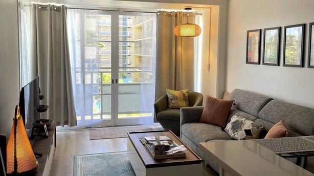 A modern living room with a sofa, coffee table, and a TV.