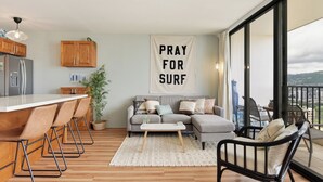 Een moderne woonkamer met een keukenhoek, een eethoek en een balkon met uitzicht op de stad.