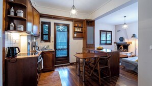 A compact kitchen with wooden cabinets, a coffee maker, and a built-in oven. - The Foxes - Modern 1BD apartment in the Forest

 (RPPV+R99 Potamia, Greece)