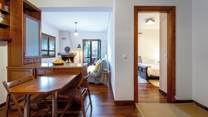 A spacious kitchen with wooden cabinets, a dining table, and a cozy seating area. - The Foxes - Modern 1BD apartment in the Forest

 (RPPV+R99 Potamia, Greece)