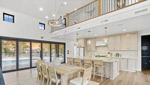 A spacious kitchen with wooden cabinets, a central island, and pendant lighting. - Zion Riverfront Farmhouse (Virgin)