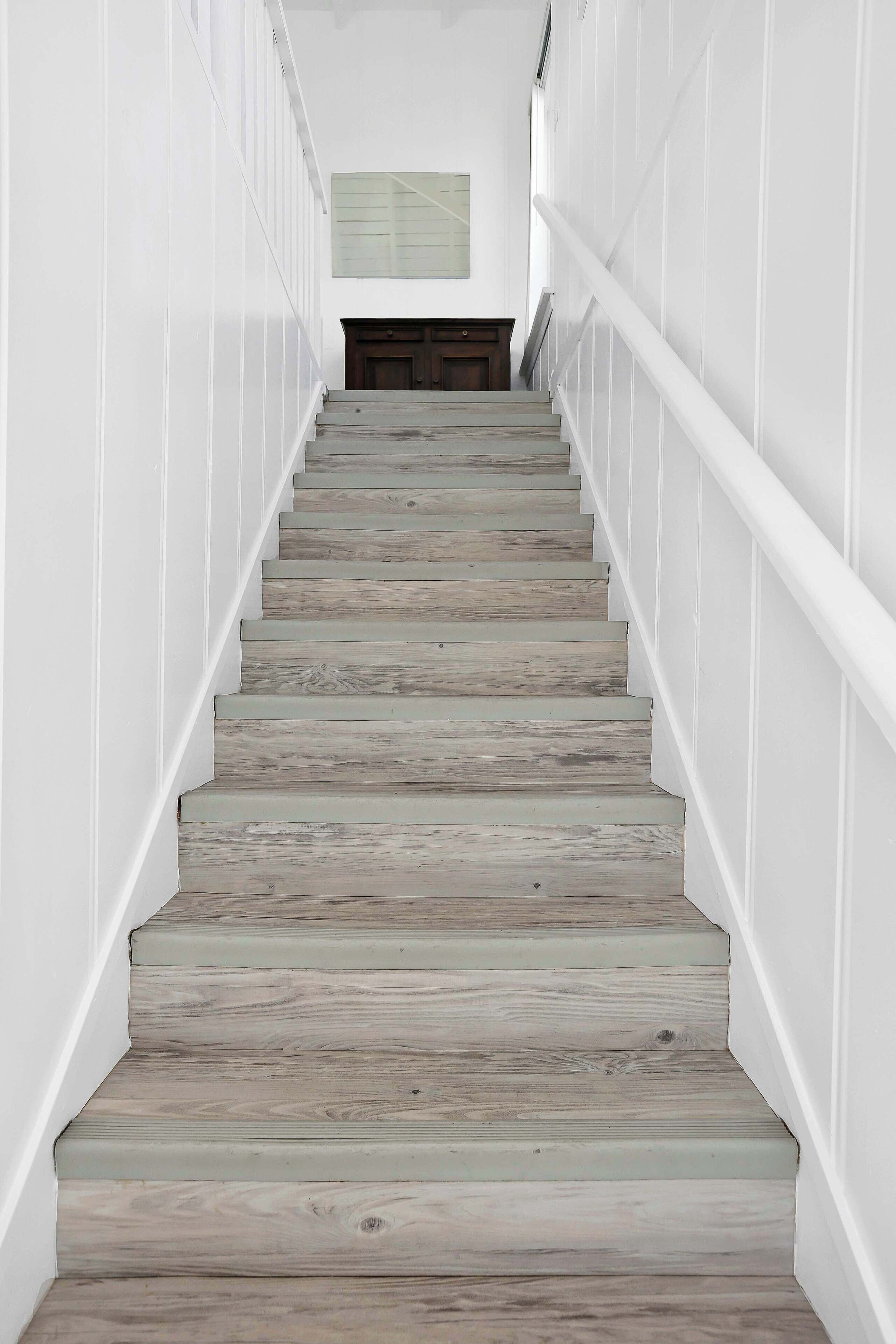 Een trap met houten treden en witte wanden.
