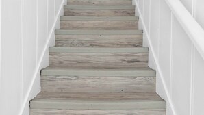 A staircase with wooden steps and white walls.