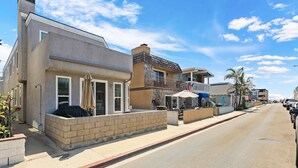 A street view of a residential area with houses, a sidewalk, and parked cars. - Newport Beach Retreat Steps to Sand, Boardwalk and Pier (Newport Beach)