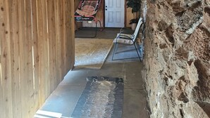 Un interior de madera con pared de piedra, una puerta y una cancha de baloncesto.