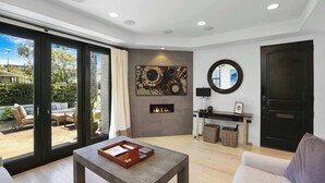 Un salon spacieux doté d’une cheminée, d’une grande fenêtre et offrant une vue sur l’extérieur.