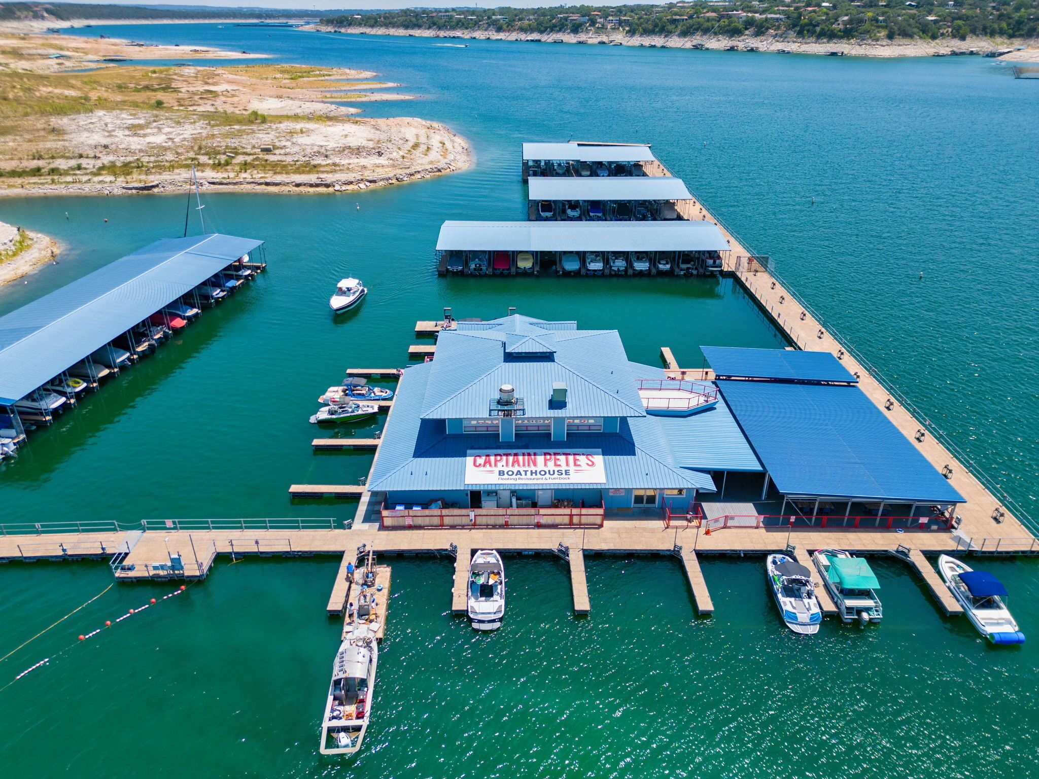An aerial view of a marina with multiple docks, boats, and a building labeled "Captain Pete's Boathouse".