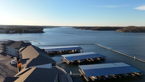 A marina with several covered boat docks and a large building with a parking lot. - Happy Haven @ Lands End – 3 BDR Resort Condo! (Osage Beach)