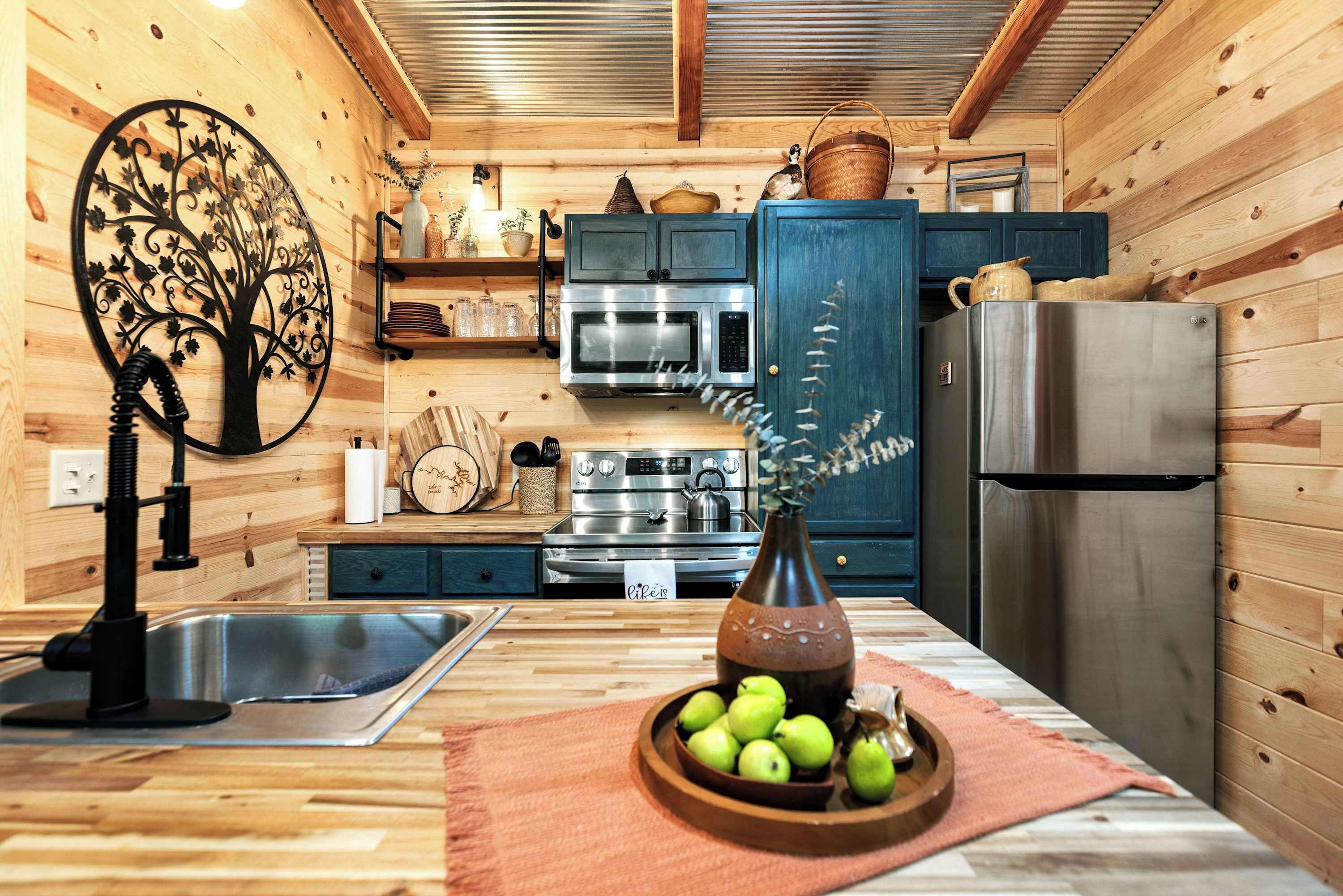 A wooden interior with a kitchen area featuring a sink, stove, oven, and refrigerator.