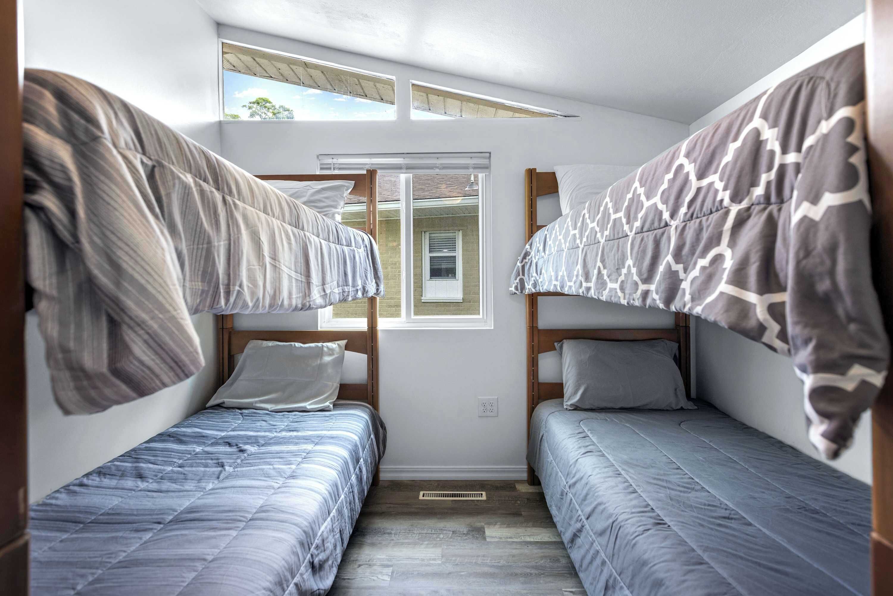 A dormitory room with two bunk beds, a window with a view, and a skylight above.