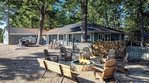 A cabin with a fire pit, outdoor seating, and a covered porch.