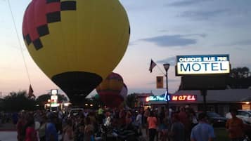 A busy street scene with a large yellow hot air balloon and a motel sign.