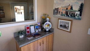 A reception desk with a welcome sign, framed pictures, and informational brochures. - Blue Pine Motel (Panguitch)