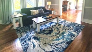 A living room with a sofa, coffee table, and a patterned rug.