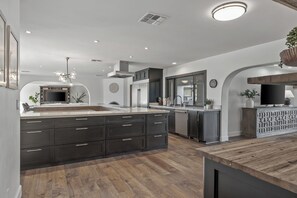 Enjoy cooking in this well-equipped kitchen with a central island, oven, and stainless steel range hood.