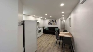 Un espace de vie compact comprenant un coin cuisine, un coin repas et un canapé.