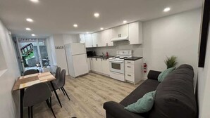 Un espace de vie compact comprenant une kitchenette, un coin repas et un canapé.