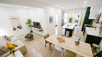 A modern apartment with a dining area, kitchen, and living space.