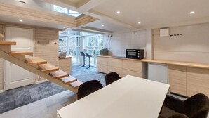 A modern kitchen with wooden accents, a dining area, and a staircase.