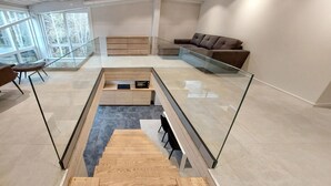 A modern living room with a glass staircase, a sofa, and a coffee table.