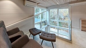 A modern interior with a large window, a sofa, and a small table.