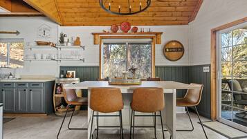 A kitchen with a central island, wooden cabinets, and a large window.