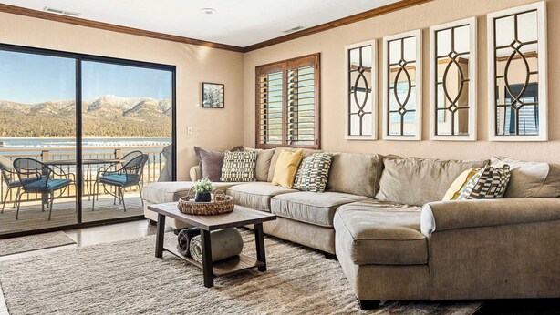 A living room with a large window, a sofa, a coffee table, and a view of mountains.