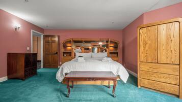 Un dormitorio con cama, armario de madera, mesita de noche y cómoda.