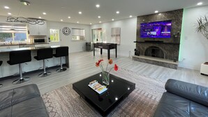 A modern living room with a black coffee table, sofas, a TV, and a fireplace. - Cozy , spacious and comfortable house. Pet friendly! And close to everything!!! (Chilliwack)