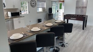 A modern kitchen with a dining area, a foosball table, and a large window. - Cozy , spacious and comfortable house. Pet friendly! And close to everything!!! (Chilliwack)