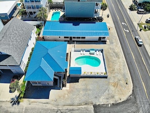 A residential property with a swimming pool, a covered patio, and a street view.