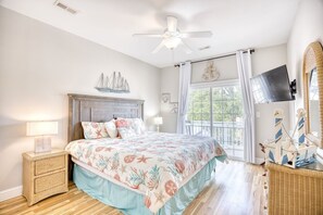 A bedroom with a bed, a nightstand, a ceiling fan, a window with curtains, and a television. - Waterfront 5 BR w/ pool & elevator Sleeps 18 (North Myrtle Beach)