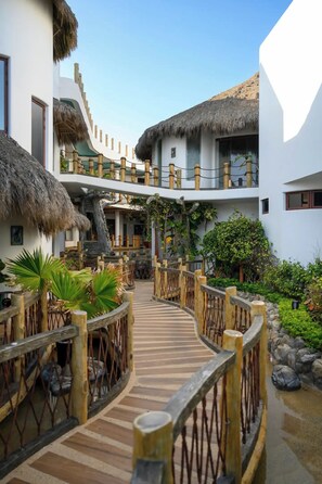 Guest rooms and pool area surround a tranquil courtyard with a naturalistic design.