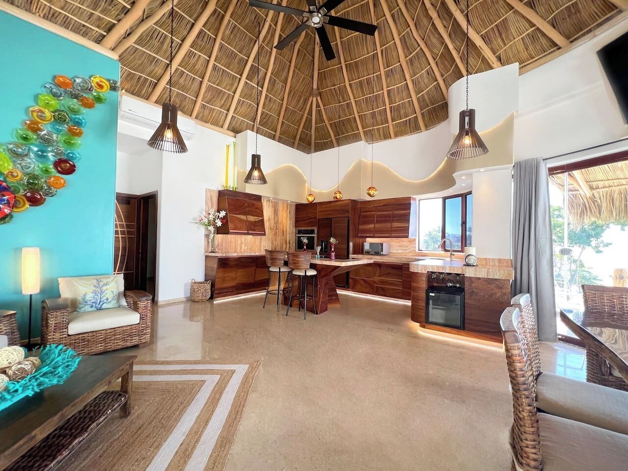 A spacious living area with a kitchen, a dining area, and a large window providing a view.