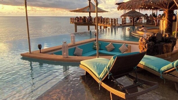 A poolside area with lounge chairs and a small boat. - Villa Crab | Puesta Del Sol Resort (La Peñita de Jaltemba,)