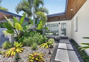 Ein modernes Haus mit Garten, Holzboden und Glastür.