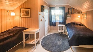A cozy room with two beds, a small table, a round rug, and a window with curtains. - Cozy home in Gravberget (Gravberget)