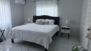 A bedroom with a bed, nightstands, a chair, and a wardrobe.