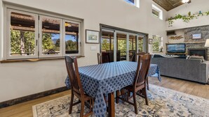 A dining area with a table set for four, wooden chairs, and a patterned tablecloth. - Hot tub, Mnt. Views, A/C, Downtown -  Eco Chalet! (Flagstaff)