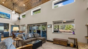 A spacious living room with a high ceiling, large windows, and a view of the outdoors. - Hot tub, Mnt. Views, A/C, Downtown -  Eco Chalet! (Flagstaff)